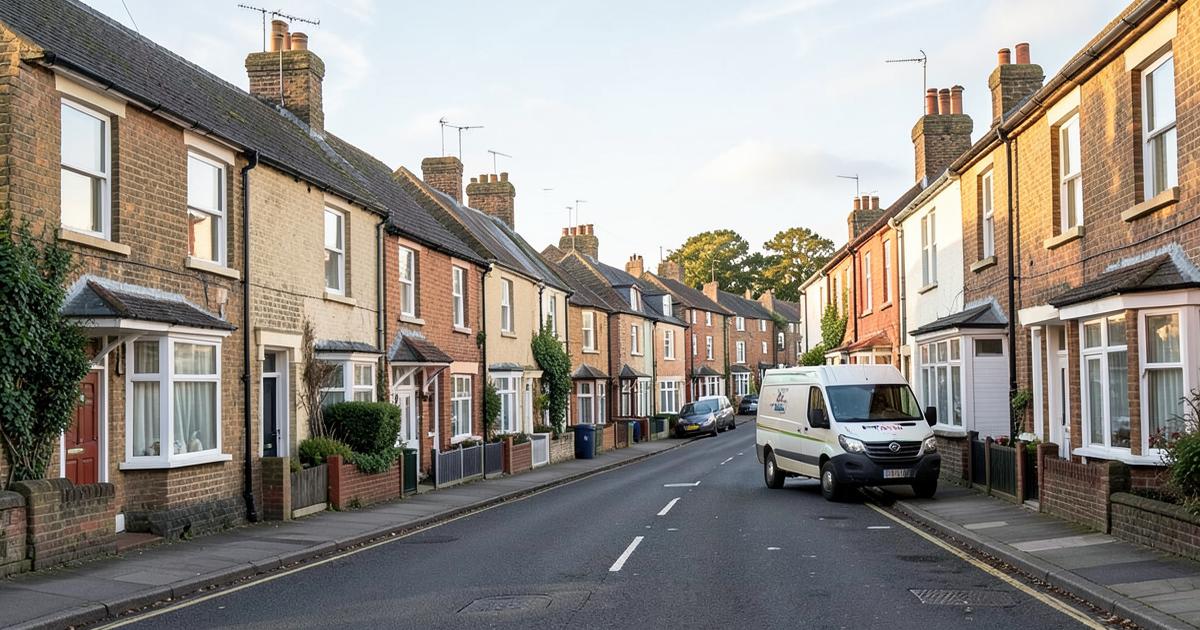 Long street of British terraced houses with a window cleaning van parked mid-round